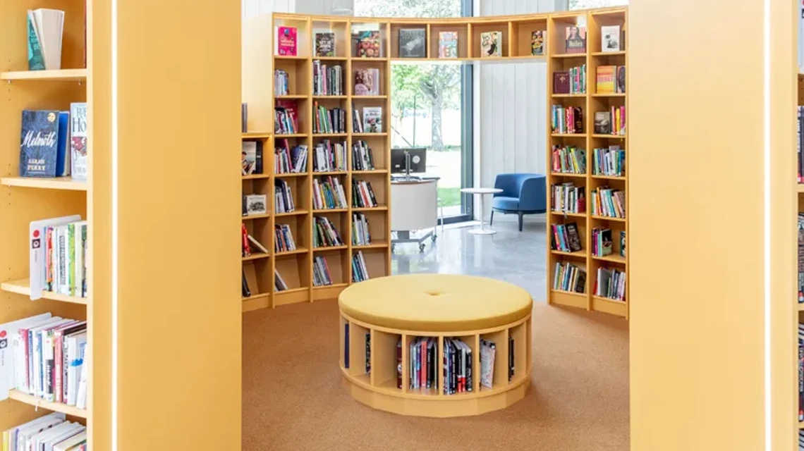Biblioteksinteriör med sittplats omgiven av bokhyllor
